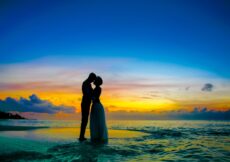 man and woman standing at seashore