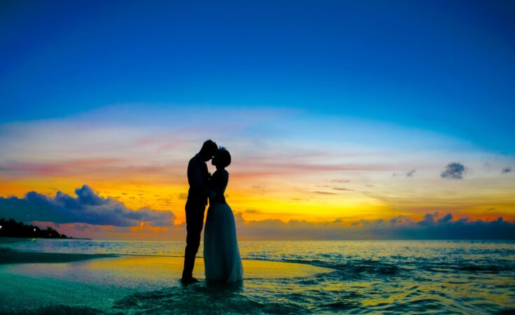 man and woman standing at seashore