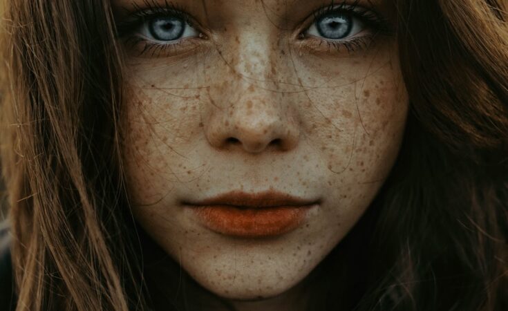 unemotional woman with freckles and big blue eyes